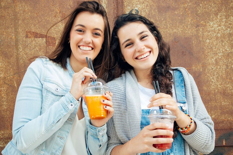 girls-smiling-holding-slushie@2x