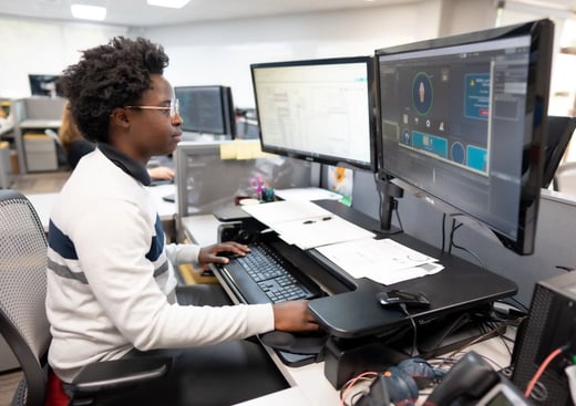 guy-looking-at-dual-monitors@2X