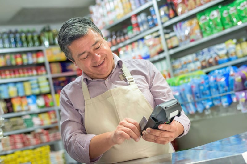 FBD Frozen. Convenience store owner swiping a customer's debit card.