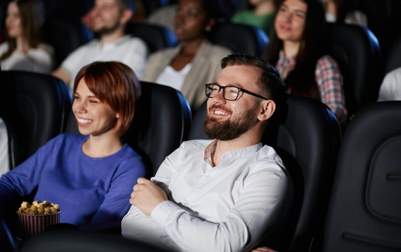 emotional-couple-watching-comedy-in-movie-theater@2x