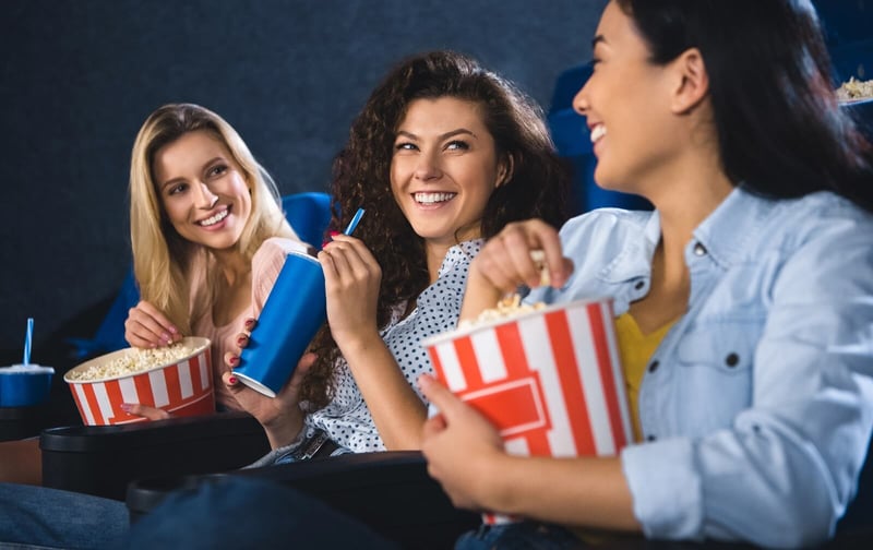 happy-multiracial-women-with-popcorn-watching-film@2x