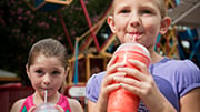siblings sipping frozen beverage