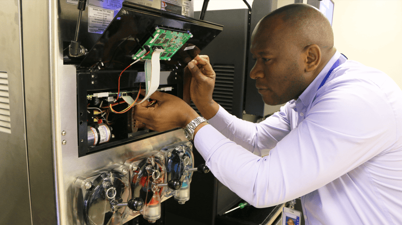 FBD Frozen. Man performing routine maintenance on his frozen beverage dispenser.