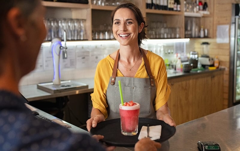 smiling-waitress-serving-strawberry-smoothie-2023-11-27-05-31-49-utc@2x